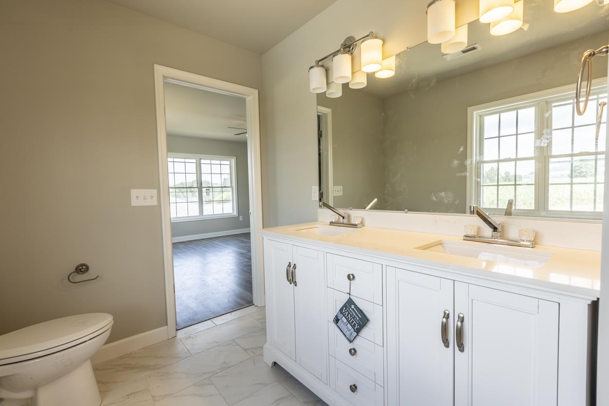 125 Rhodes Hill Drive Dayton, VA 22821 - Photo 25 of 37 a bathroom with a granite countertop sink a toilet and a mirror