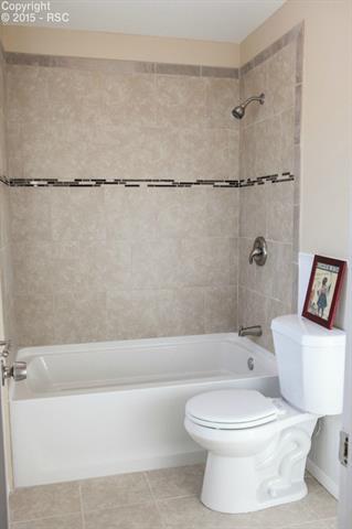 6965 Chippewa Road Colorado Springs, CO 80915 - Photo 10 of 31 Upper level bath area adjoins the master bedroom, and it has doors separating this area from the double vanity are - very private. Custom tile shower surround.