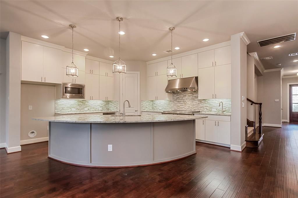a kitchen with stainless steel appliances granite countertop wooden floors wooden cabinets and sink