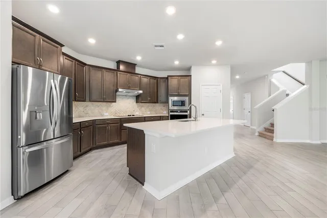 a kitchen with stainless steel appliances granite countertop a sink and cabinets