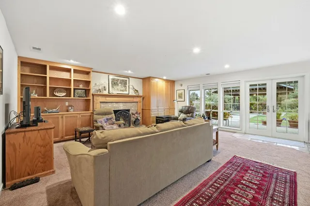 a living room with furniture a rug table and a large window