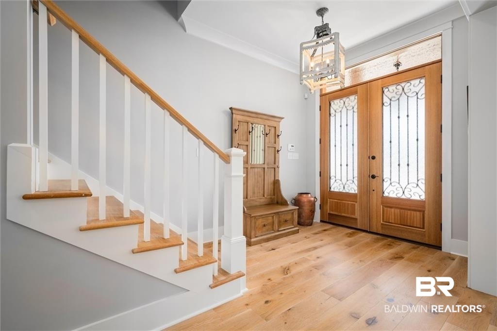 707 Cardamel Court Fairhope, AL 36532 - Photo 2 of 40 Foyer entrance featuring a chandelier, french doors, light hardwood / wood-style flooring, and ornamental molding