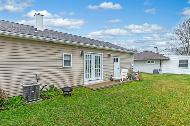 a front view of a house with a garden and chairs
