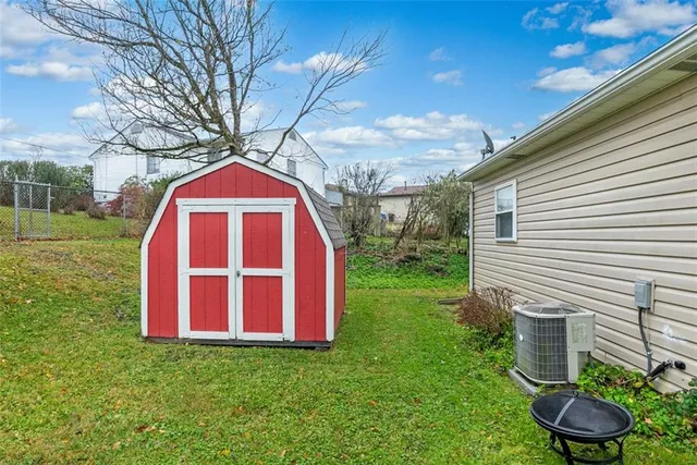 a view of a backyard with plants and a large tree
