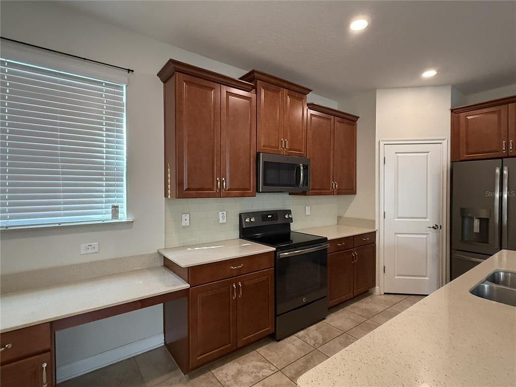 11818 Epic Avenue Orlando, FL 32832 - Photo 12 of 28 a kitchen with stainless steel appliances granite countertop a refrigerator and a sink