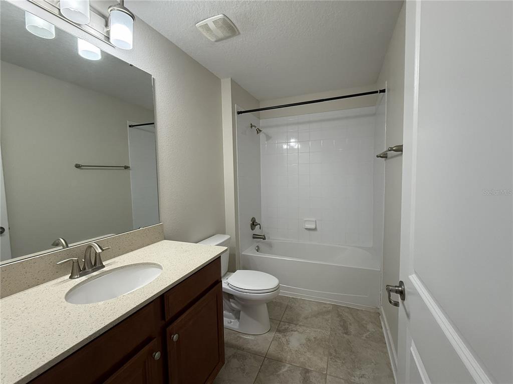 11818 Epic Avenue Orlando, FL 32832 - Photo 23 of 28 a bathroom with a double vanity sink toilet mirror and shower