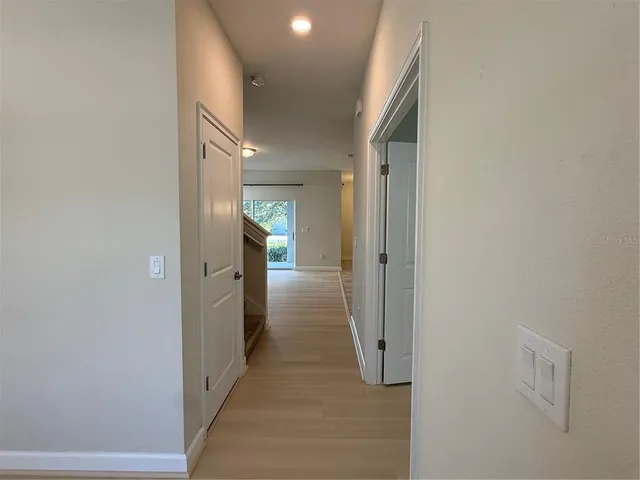 a view of a hallway with wooden floor