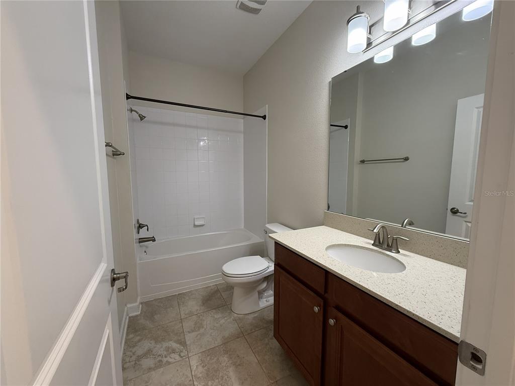 11818 Epic Avenue Orlando, FL 32832 - Photo 10 of 28 a bathroom with a sink a toilet a mirror and shower