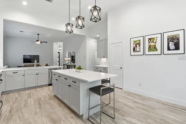 a kitchen with stainless steel appliances kitchen island granite countertop a refrigerator a stove a microwave oven a sink with island and chairs with wooden floor