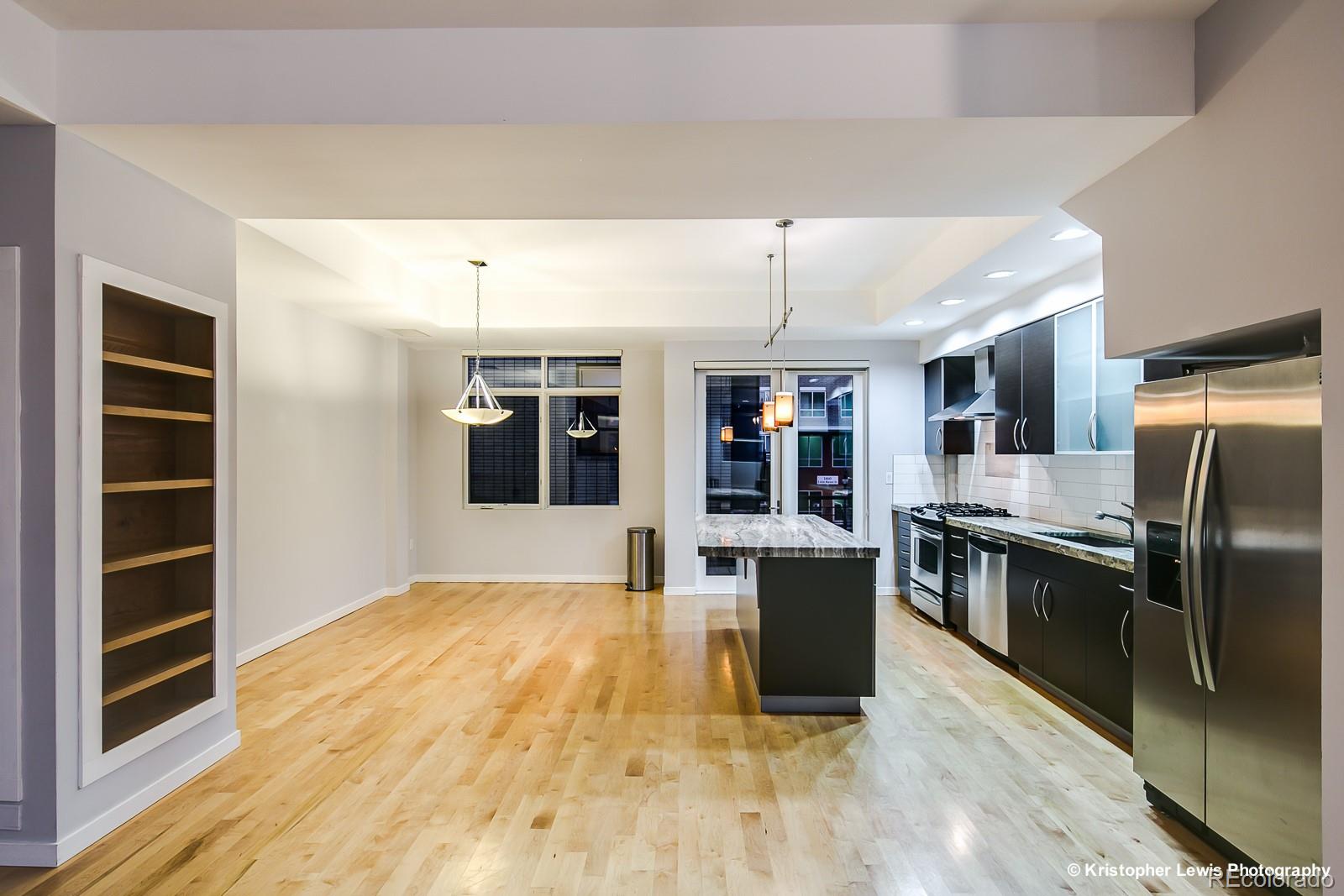 1400 Little Raven Street, Unit B Denver, CO 80202 - Photo 11 of 35 a kitchen with stainless steel appliances granite countertop a refrigerator and a stove top oven