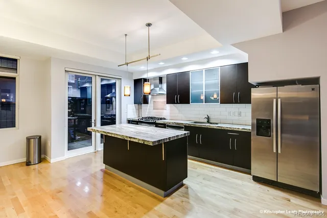 a large kitchen with stainless steel appliances granite countertop a sink counter space and wooden floor