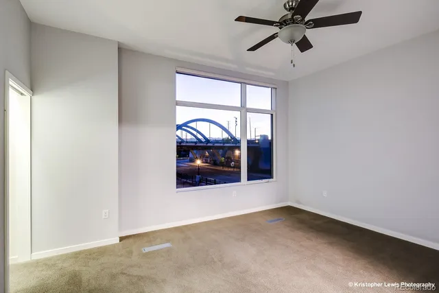 an empty room with a ceiling fan and closet area