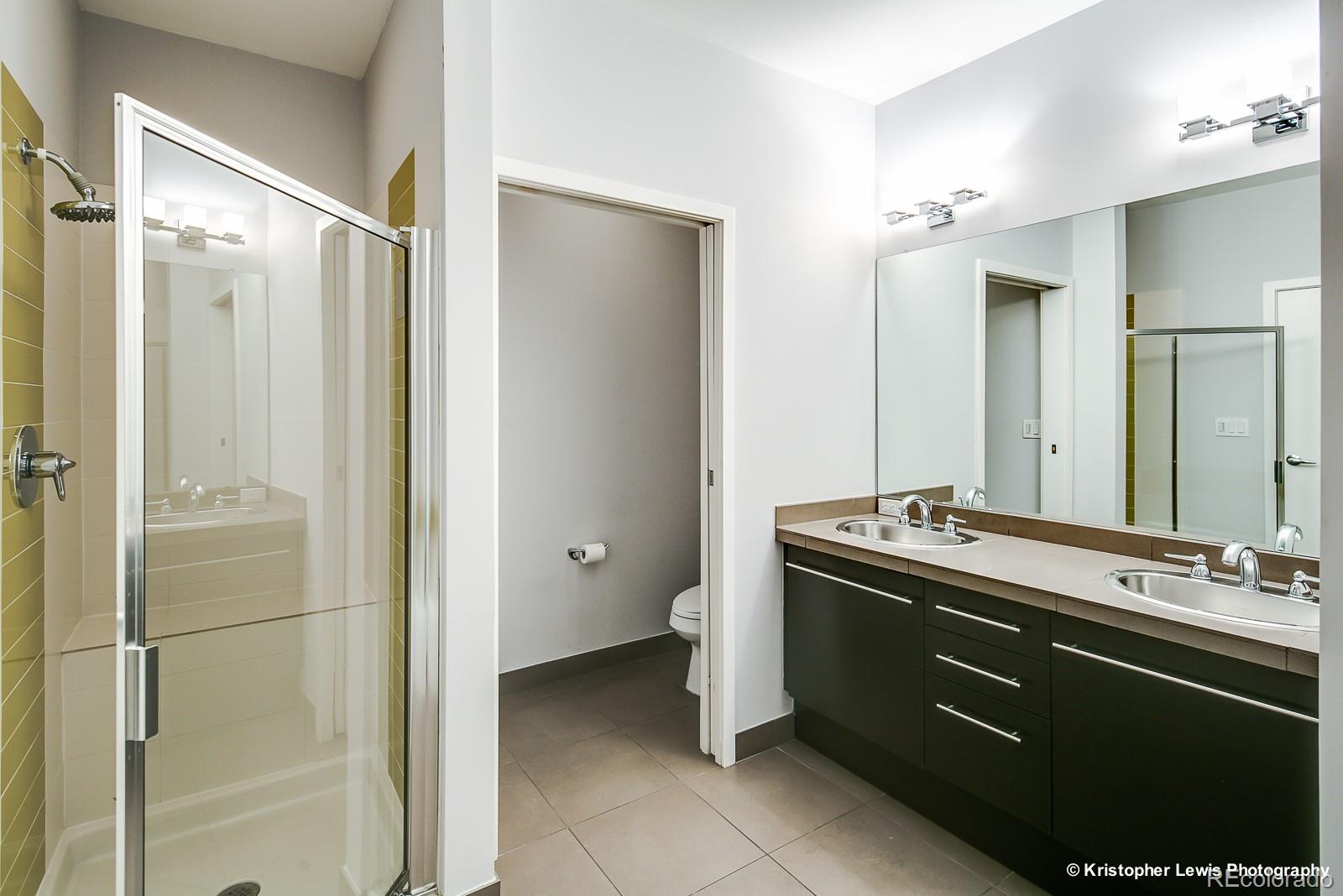 1400 Little Raven Street, Unit B Denver, CO 80202 - Photo 23 of 35 a spacious bathroom with a shower sink and mirror