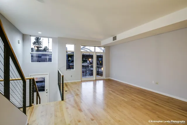 a view of a living room with wooden floors and stairs