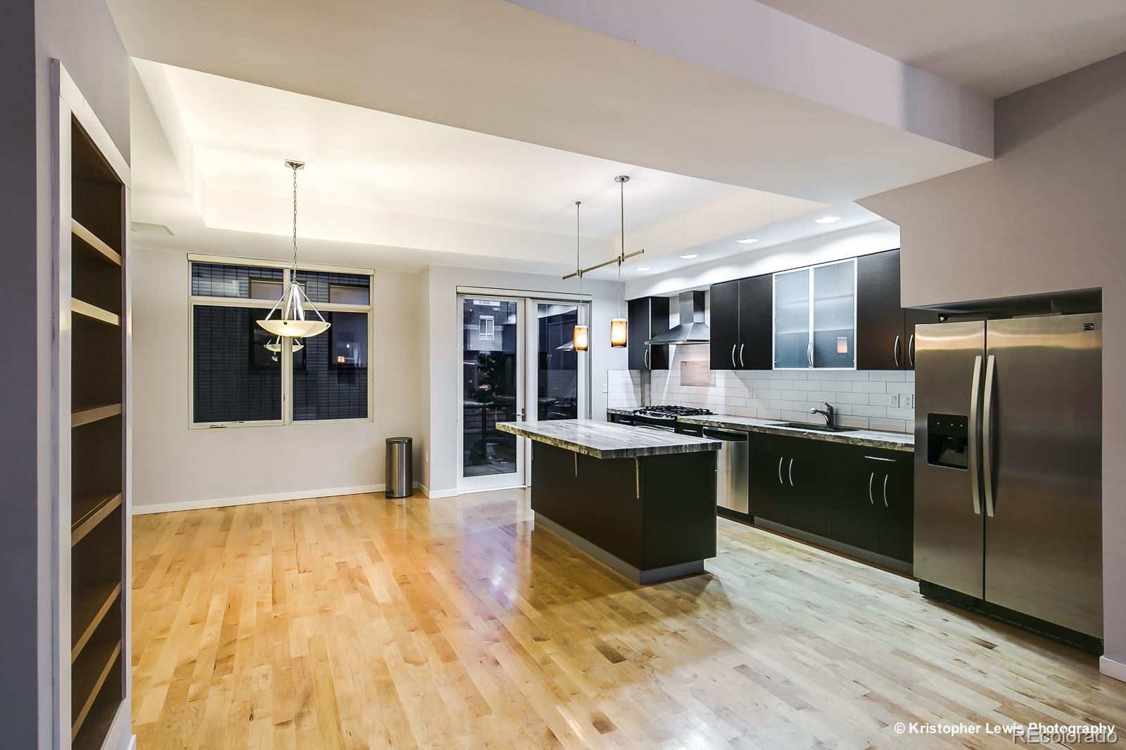 1400 Little Raven Street, Unit B Denver, CO 80202 - Photo 10 of 35 a large kitchen with a large counter top stainless steel appliances and cabinets
