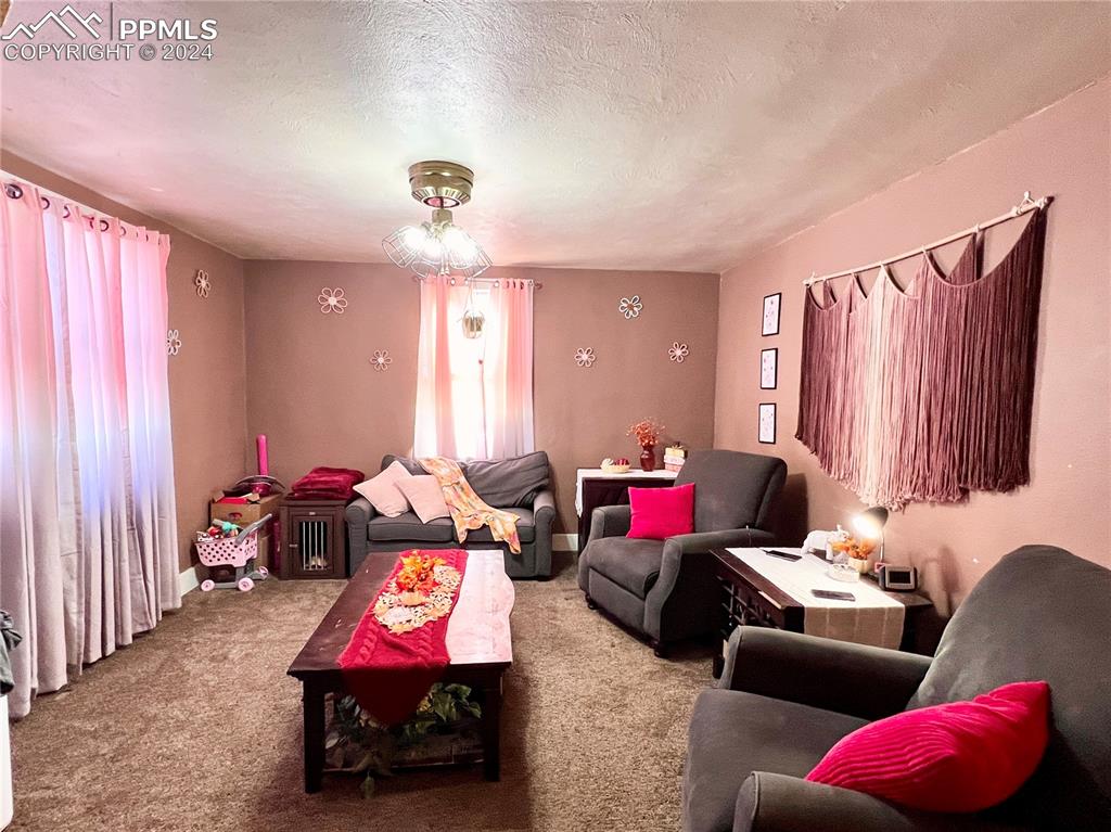 408 9th Street Fowler, CO 81039 - Photo 2 of 13 a living room with furniture and a chandelier