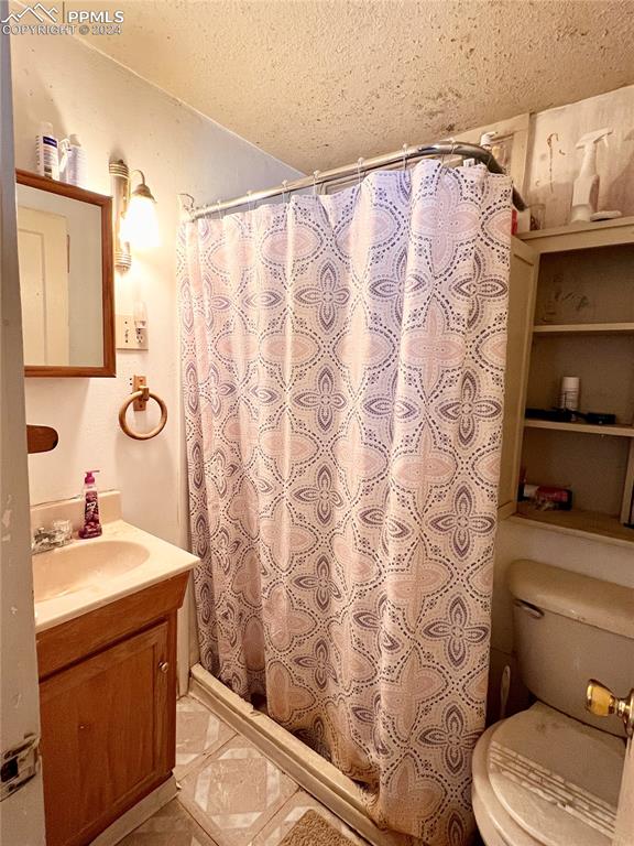 408 9th Street Fowler, CO 81039 - Photo 9 of 13 a bathroom with a sink a toilet and shower curtain