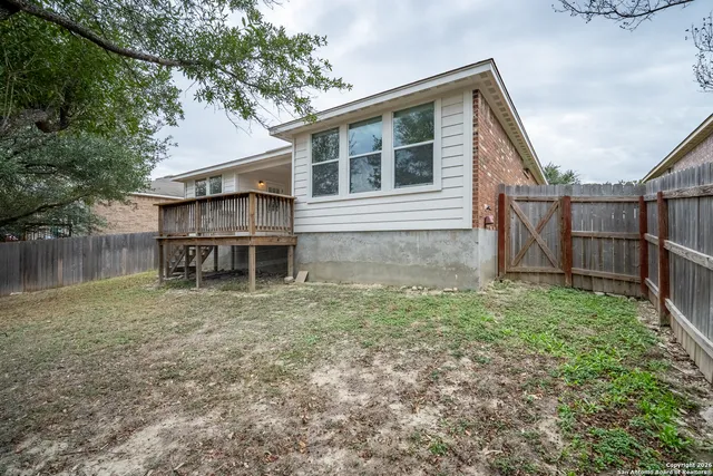 a backyard of a house with wooden floor and fence