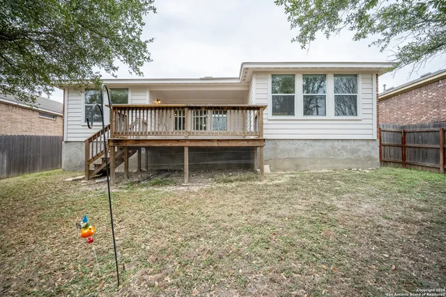 a view of house with a backyard and balcony