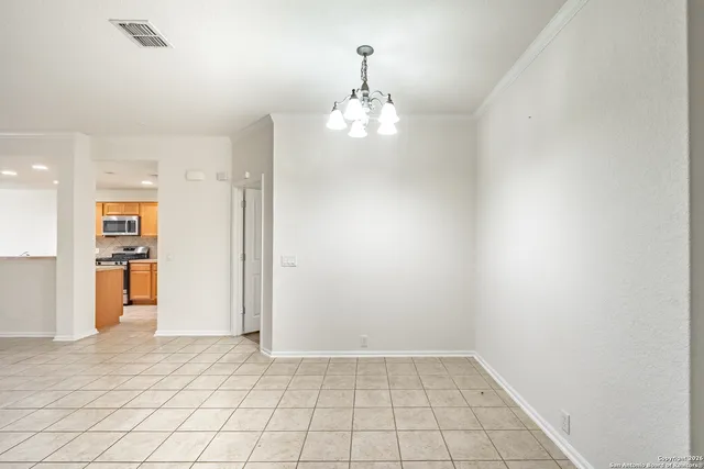 an empty room with kitchen view and a window