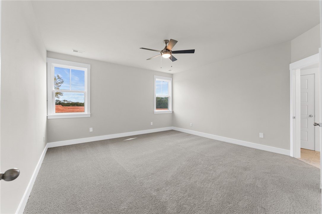 167 Tiger Lily Drive Anderson, SC 29621 - Photo 10 of 34 A well-lit bedroom with ample natural light, featuring plush carpeting and a modern ceiling fan.
