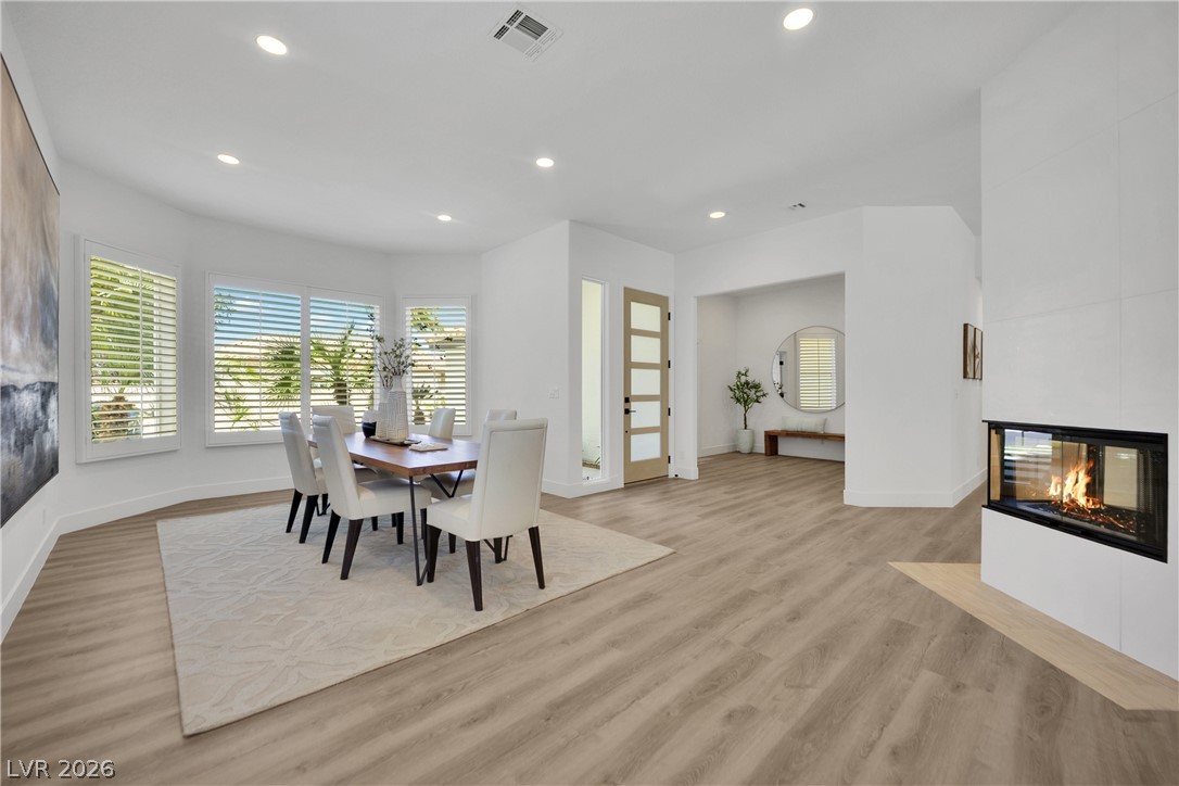 8981 Rivers Edge Drive Las Vegas, NV 89117 - Photo 6 of 69 An inviting open-concept dining room boasts a modern fireplace and abundant natural light.