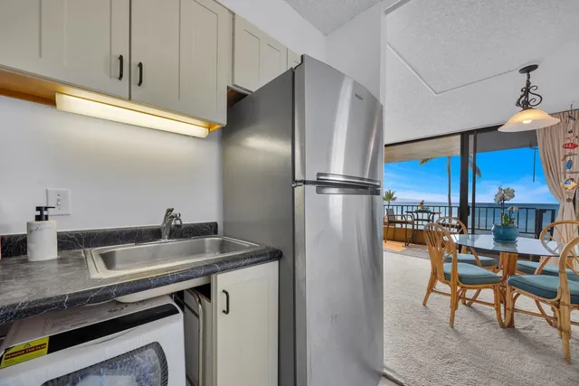 a kitchen with stainless steel appliances granite countertop a sink refrigerator and cabinets