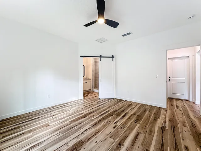 a view of an empty room with wooden floor