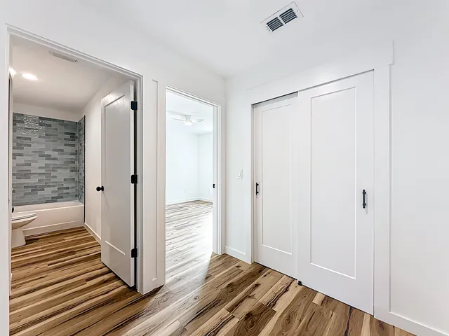 a view of a hallway with wooden floor and staircase