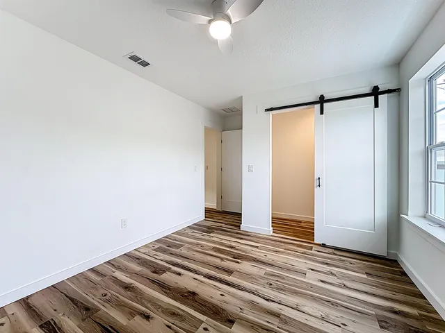 a view of a room with wooden floor and white walls