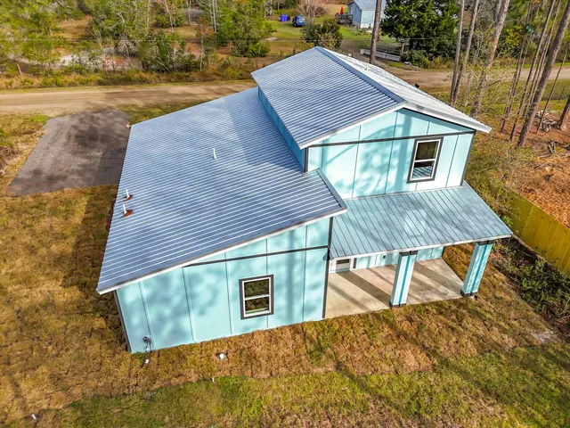 a view of a house with backyard and sitting area