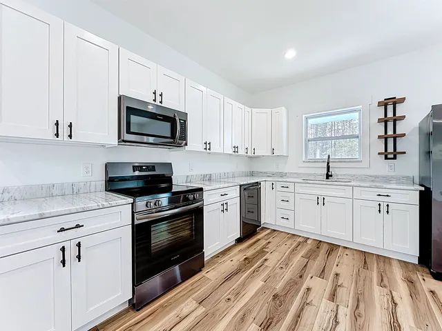 a kitchen with cabinets stainless steel appliances a sink and a counter space