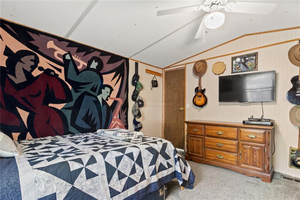 3650 176 Place Inglis, FL 34449 - Photo 28 of 52 a bedroom with a bed and a flat tv screen on dresser