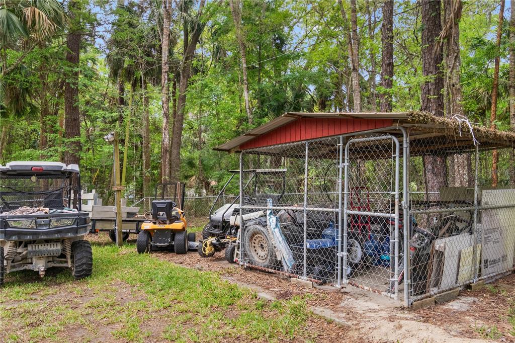 3650 176 Place Inglis, FL 34449 - Photo 41 of 52 a view of a chair and tables in the back yard of the house