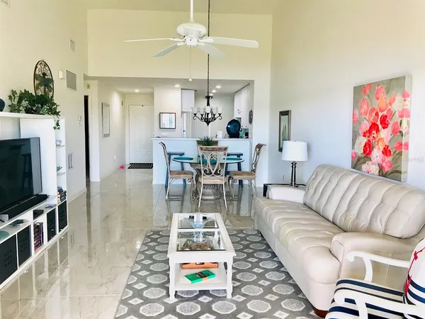 a living room with furniture a flat screen tv and a chandelier