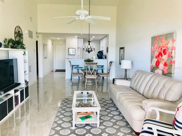 a living room with furniture a flat screen tv and a chandelier