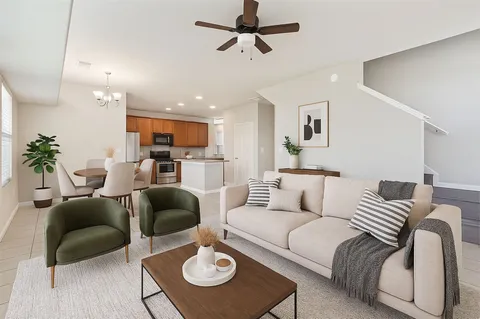 a living room with furniture a rug and a ceiling fan