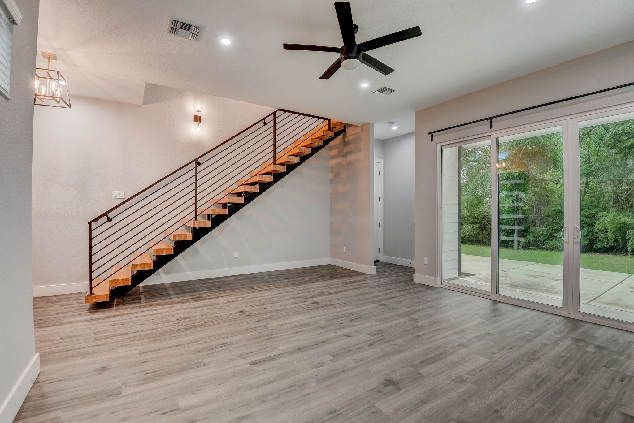 2507 Rogge Lane, Unit 2 Austin, TX 78723 - Photo 10 of 30 a view of an empty room with wooden floor stairs and a ceiling fan