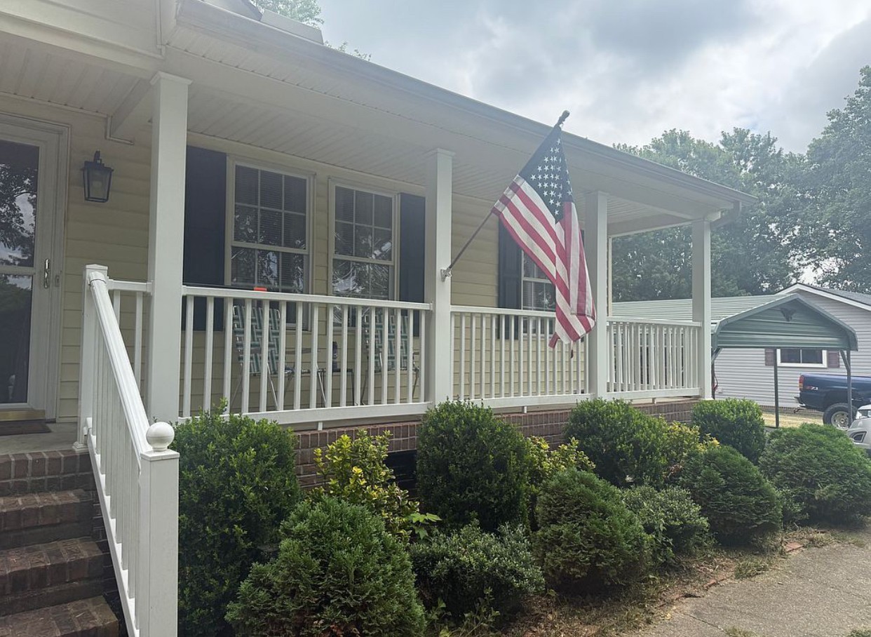 a view of a house with a small yard and wooden floor and fence