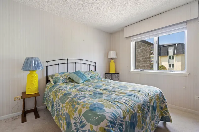 a bedroom with a bed and painting on the wall