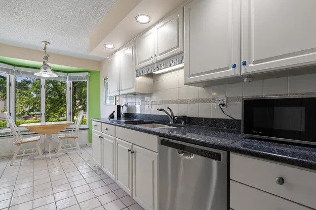 a kitchen with granite countertop a sink and a stove