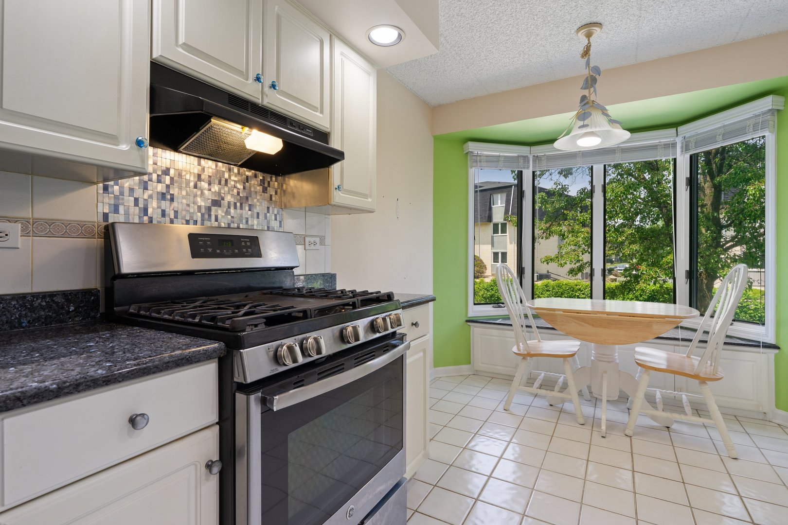 3640 186th Street, Unit 101 Lansing, IL 60438 - Photo 8 of 17 a kitchen with stainless steel appliances granite countertop a stove a sink and a microwave