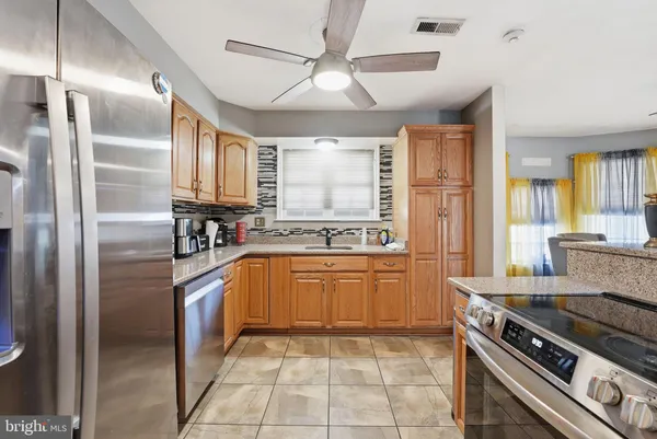 a kitchen with stainless steel appliances granite countertop a stove a refrigerator and a sink