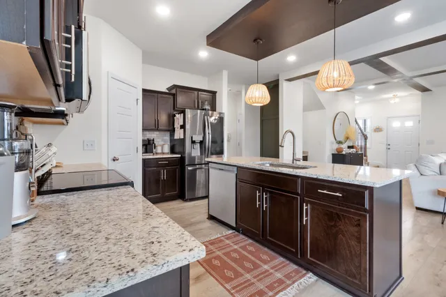 a kitchen with a sink and a stove top oven with wooden floor