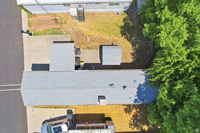 1525 South 400 East, Unit 13 Springville, UT 84663 - Photo 27 of 32 Aerial view of the property featuring a light grey shingle roof, a detached shed with a light grey shingle roof, paved driveway, concrete patio, and mature trees