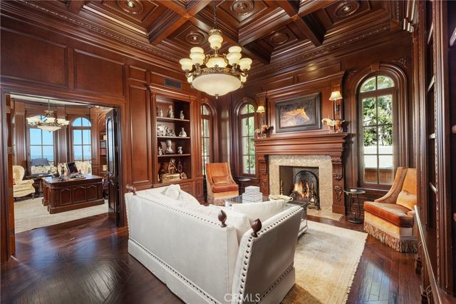 a living room with furniture a bookshelf and a chandelier