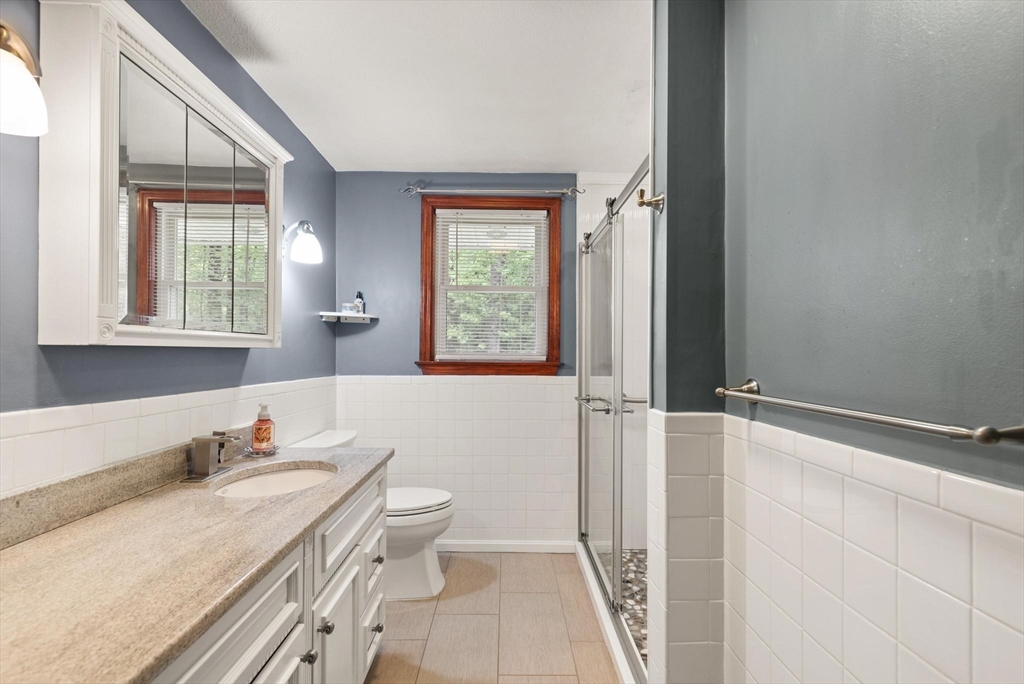 901 Haverhill Street Rowley, MA 01969 - Photo 31 of 42 a bathroom with a granite countertop sink mirror vanity and a toilet