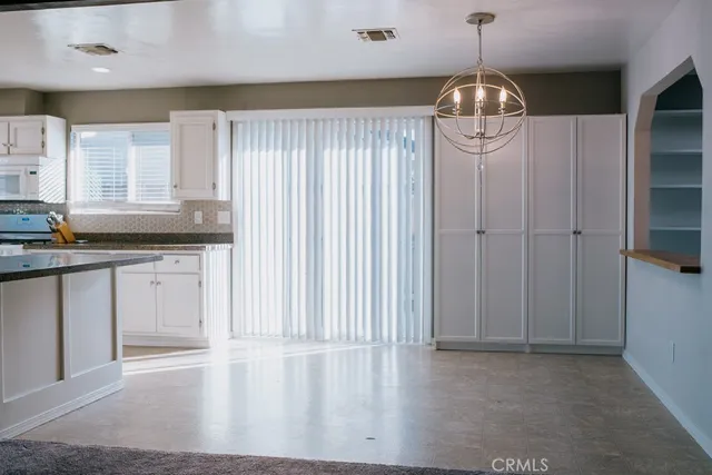 a kitchen with granite countertop white cabinets and white appliances