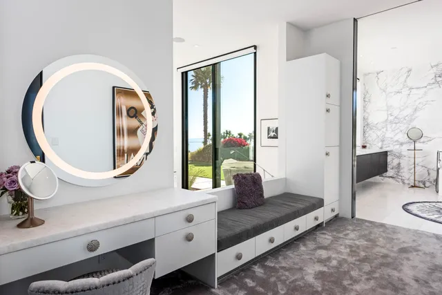 a bedroom with a bed a mirror and a large window