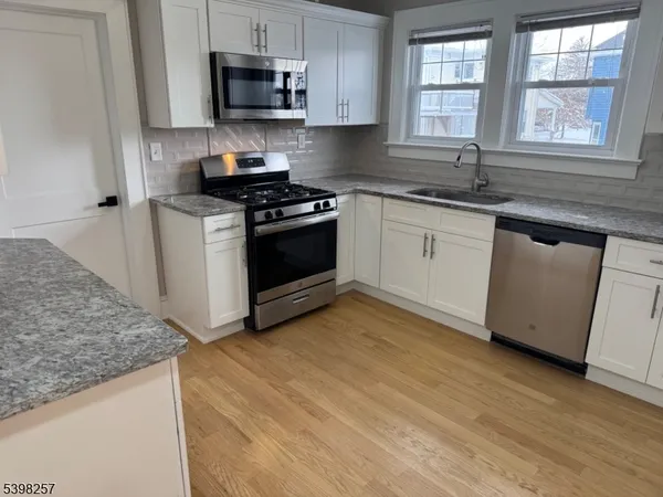 a kitchen with granite countertop a sink and a stove top oven